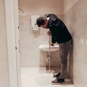 Rilievo tecnico di un bagno con misurazione del lavabo per valutare la conformità agli standard di accessibilità.